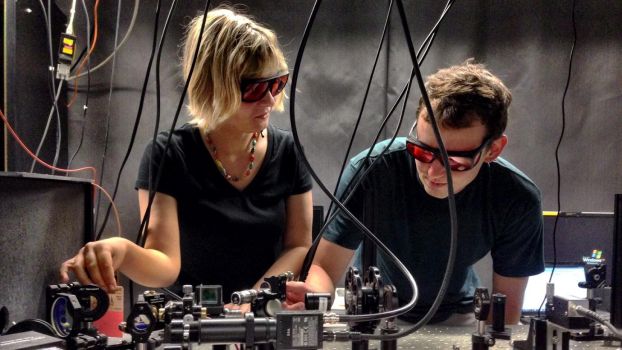 Two researchers wearing protective eyewear stand at a laboratory set-up